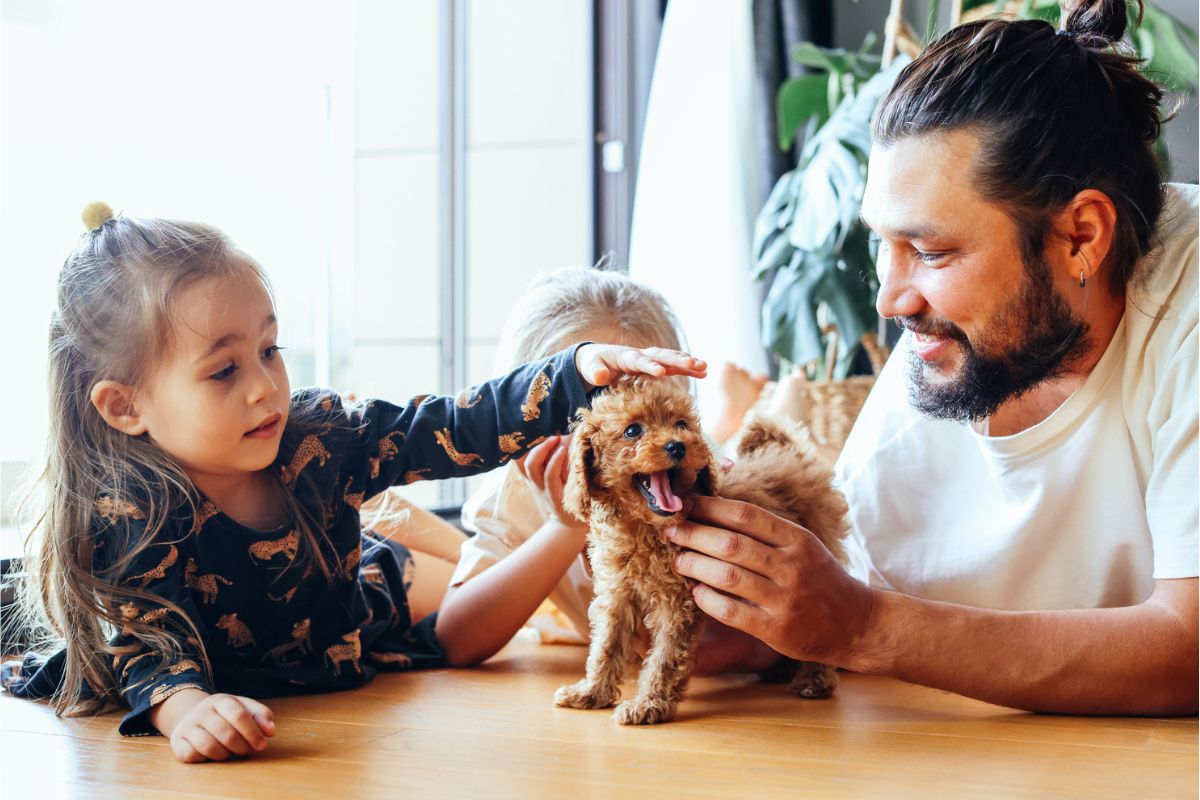 Father and kids patting a puppy