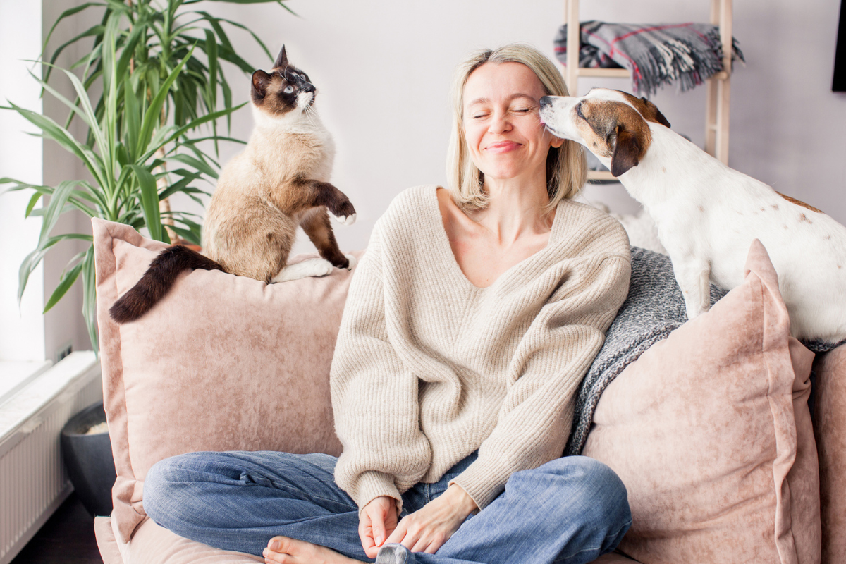 Lady on couch with dog licking her face